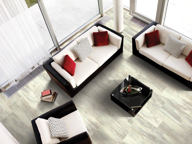 Mohawk marble lvt floors offer a luxurious feel to a bright living room with tall windows.